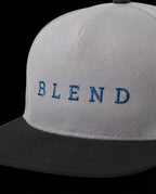 Aurulu Blend Snapback Cap with printed material, showcasing a stylish, adjustable black and white cap with graphic design.
